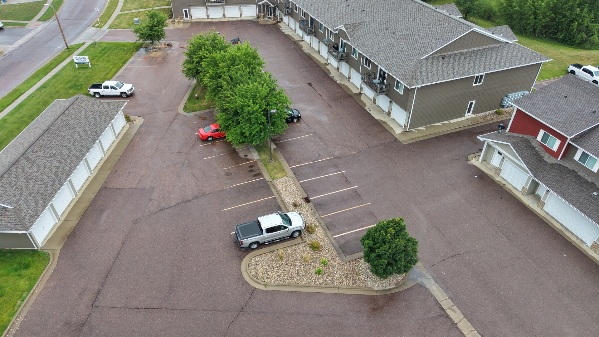 Aerial drone view of a Sioux Falls apartment parking lot with faded striping before Gold Line Striping repainted it
